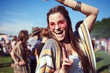 Young woman in pink sunglasses poses for the camera at a music festival