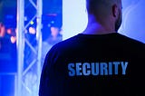 A big guy with his back turned and the word,”Security” printed on his shirt.