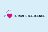 An image with the text “I ♥ HUMAN INTELLIGENCE” on a light blue background. The word “STILL” is written above and pointing to the heart symbol.