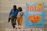 A freeze frame from a late 1970’s television advertisement for Total cereal; a couple walk arm in arm along a beach, paired with an overlay showing a box front of Total and the text: “Today. Start it right with ‘TOTAL.’”