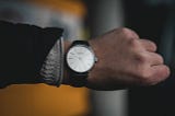 Man’s hand with an analog watch showing a time of 10:08