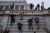 Insurrectionists climbing the walls of the Capitol on 1/6/21