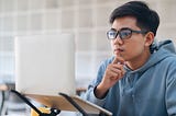 A boy reading from a laptop.