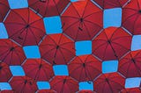 red umbrellas against a blue sky background