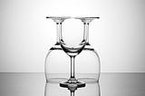 Three clear wine glasses, stacked in a symetrical way