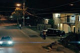 Lens flare as car draws up in neighborhood at night