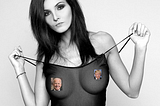 woman wearing a transparent nightie. Nipples are covered by portrait of Biden and Trump