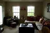 A sectional and chair sit in the living room of my last apartment.