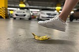 A foot is about to step onto a banana peel.