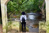 Black American woman standing near the river where Europeans bathed kidnapped Africans before selling them