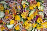 an image of the mago salad, vibrant colors from magoes, jalapenos, red onion cucumbers and tomatoes