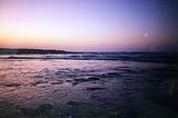 The ocean in a purple nightfall light.