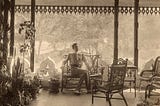 Adolf de Meyer sits on a bench as light illuminates him.