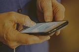 Someone textign on a phone, close up of just the hands and phone.