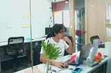A picture of Milthon sitting in front of his desk while working.