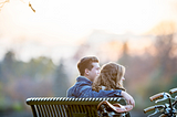 Couple holding each other on a bench