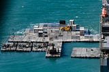 Army mariners work to construct a causeway adjacent to the MV Maj. Bernard F. Fisher off the coast of Bowen, Australia, July 28, 2023. When complete, the causeway will form a floating pier enabling the discharge of vehicles from the Fisher to shore demonstrating the critical capability of Joint Logistics Over-the-Shore (JLOTS) during Talisman Sabre.