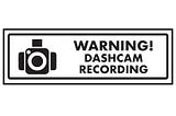 A black and white image of a camera with “Warning! Dashcam recording”