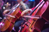 Performers play the cello at a concert.