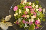A salad topped with rose and peony petals.