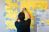 I was captured writing physical post-it notes in a co-design workshop