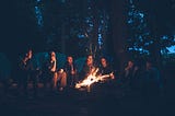 Friends sitting around a campfire.
