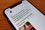 Dutch-language chat messages about Scrum books, displayed on the screen of the author’s iPhone, atop a wooden table