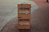 A sign on a walkway with an arrow showing left and one to the right. It reads “awesome” over the arrow leading to the right and “less awesome” over the other.