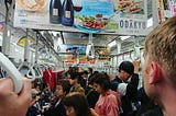 The back of my husband’s head as he looks into a packed Tokyo subway train