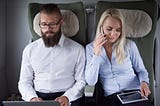 A man and woman sitting next to each other on a flight