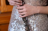 Woman in sparkly dress holding a shiny flute