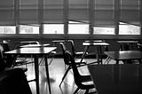 Salón de clases vacío en blanco y negro.