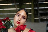 Woman with Red Eye Shadow Holding Red Roses