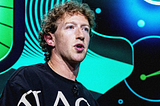 A person with curly brown hair speaks passionately against a vibrant, abstract background in green and blue tones, conveying a sense of energy.