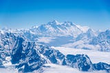 Mount Everest, the tallest mountain in the world, sits in the background covered in snow. Explorers long wanted to climb in the pursuit of human achievement.