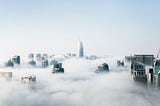 A cityscape viewed from above the clouds.