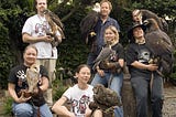 Seven people are holding different types of birds, including owls, eagles, a hawk and peregrine falcon. Leslie Zacher, bottom left, is holding a barn owl. This photo was taken at a Sarvey Wildlife Care Center fundraiser in 2008.
