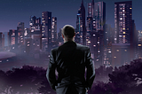 Man in suit looking out over city at night