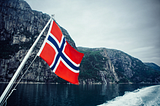 Norwegian flag with an eerie fjord in the background