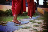 Buddhist monks walk along a path representing the journey of forgiveness and loving-kindness.