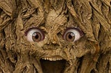 a face with a wide open mouth in a tree trunk