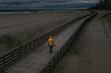 A person walking along a beach walk