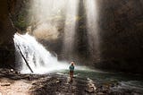 Woman near a frothy waterfall.