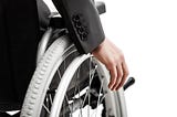 Image shows arm in a suit jacket pushing their wjeel on their manual wheelchair.