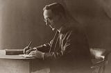 Black and white, old photo of a man’s side profile, writing a letter