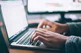 Man writing web content on a laptop