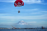 A red parasail in the Puget Sound in Washington with Mount Rainier in the background. Photo by Rene Cizio