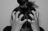 Black and white photo of a person pulling their hair out in frustration