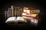 A nicely arranged collection of antique books against a black background.