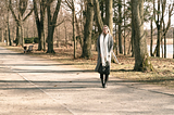 A woman in winter attire strolls through a serene tree-lined park on a sunny day. How to drastically increase your cardiovascular fitness when you can’t go to the gym or go out for a run